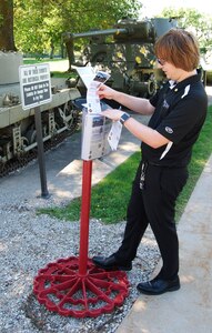 Mark Struve of the ASC History Office places historical brochures in a box at Memorial Field on Rock Island Arsenal