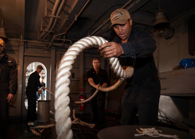 Seaman Isaiah Harris, from Centreville, Virginia, assigned to the deck department aboard the aircraft carrier USS Gerald R. Ford (CVN 78), heaves in a mooring line during a sea and anchor evolution. Gerald R. Ford departed Huntington Ingalls Industries-Newport News Shipbuilding and returned to sea for the first time since beginning their post-shakedown availability in July 2018 to conduct sea trials.