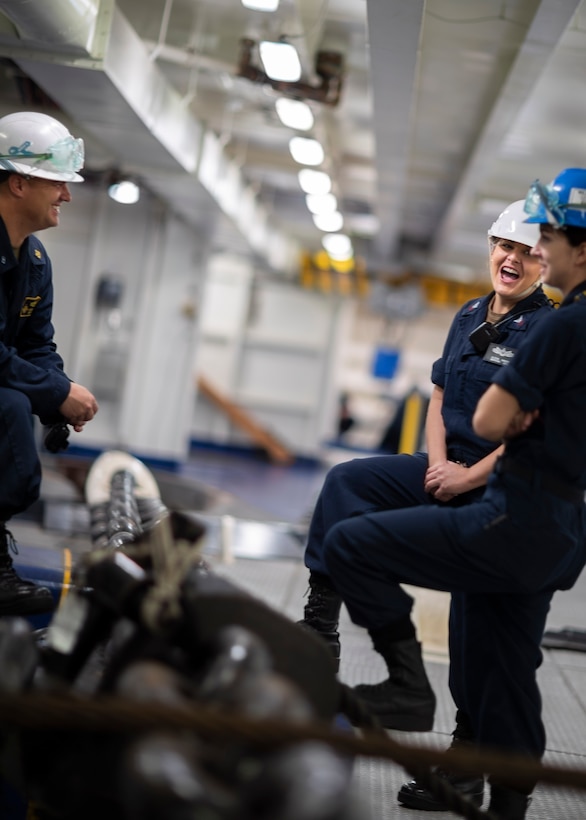Boatswain’s Mate 1st Class Alexa Macri middle, from Huntington, West Virginia, Chief Warrant Officer Steven Sturm, left, from Los Angeles, and Boatswain’s Mate 2nd Class Natia Ellam, from Williamsburg, Pennsylvania, all three assigned to the deck department aboard the aircraft carrier USS Gerald R. Ford (CVN 78), take a break from sea and anchor during sea and anchor detail, Oct. 25, 2019.