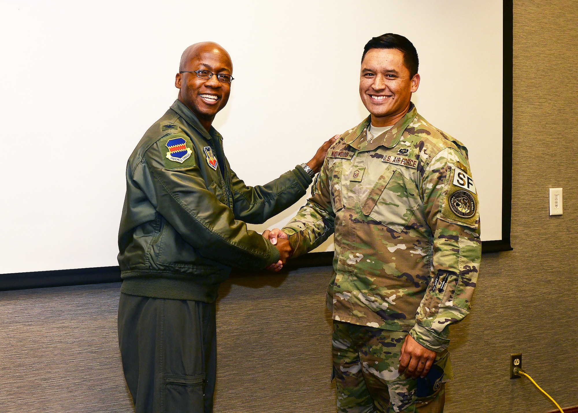 Col. Gavin Marks, 55th Wing commander recognizes Master Sgt. Jared Norwood, 55th Security Forces NCO in charge of elite guard operations with a coin for his commitment during the POW/MIA Remembrance Run Oct. 6–7. Norwood ran 81.37 miles over a 24-hour timespan to honor the men and women of the POW/MIA community.