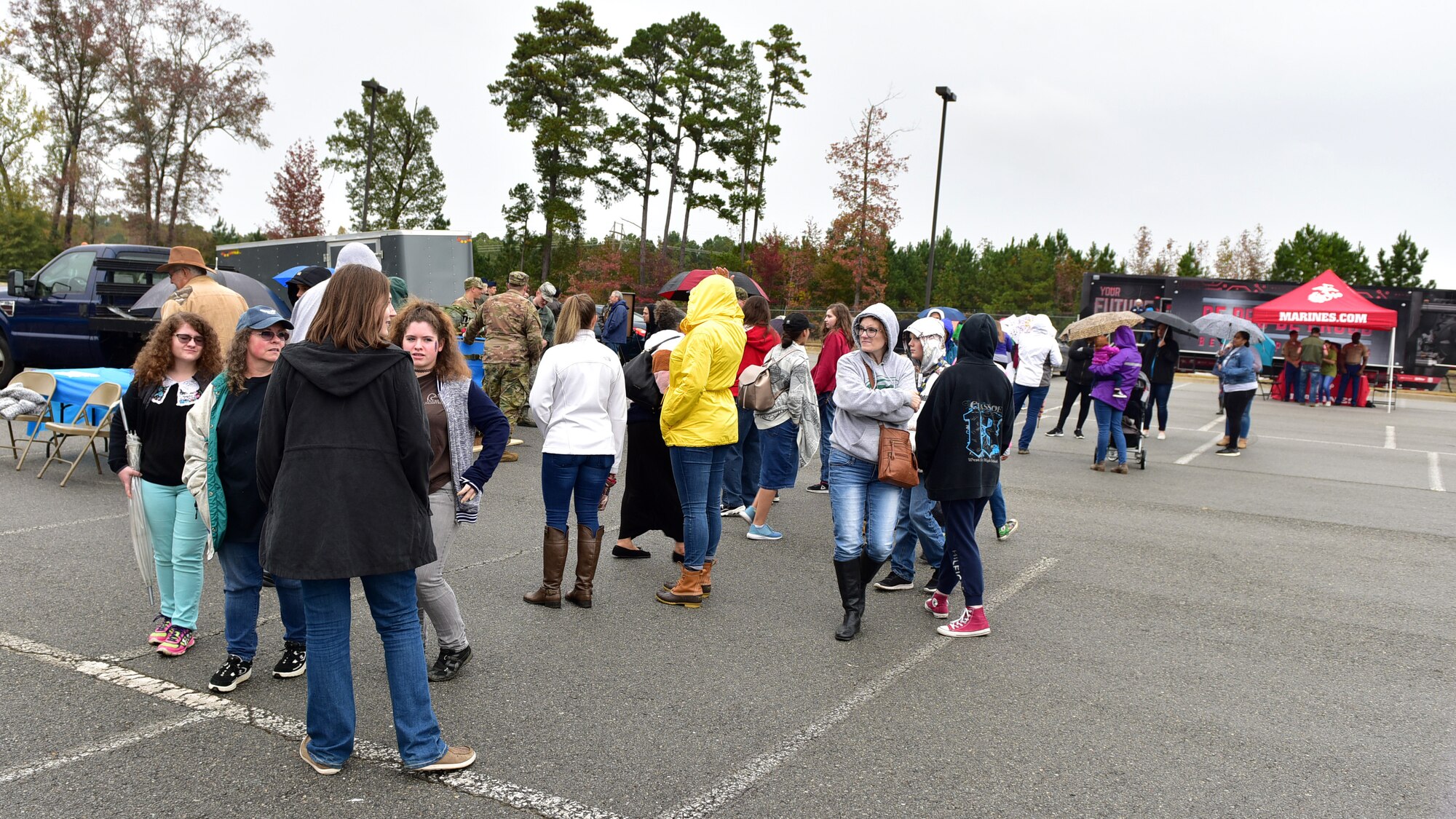 People outside gather around displays and demos during a career fair.