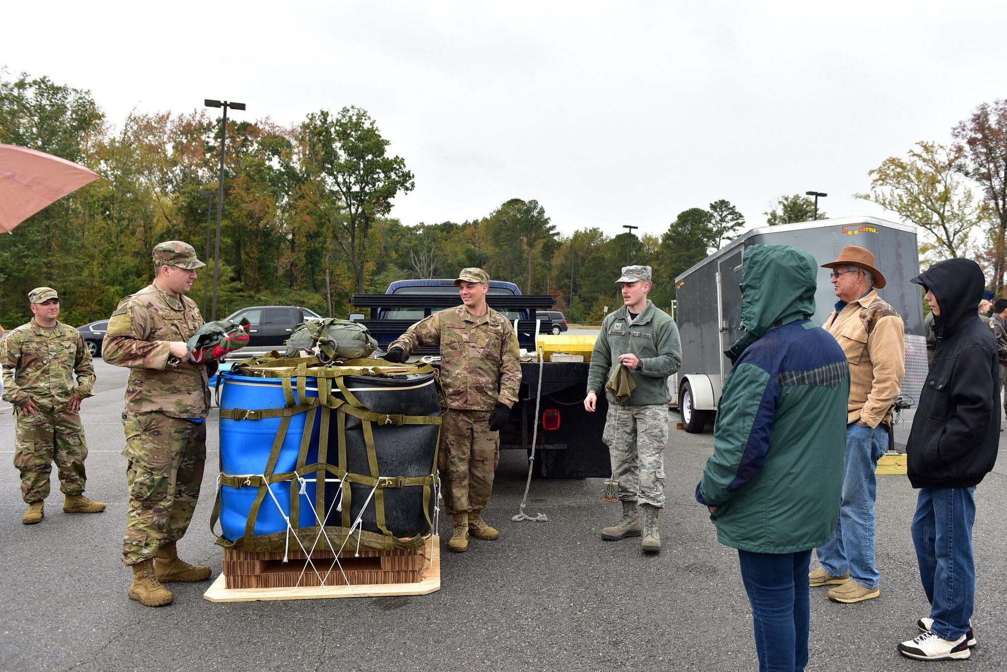 People outside gather around displays and demos during a career fair.