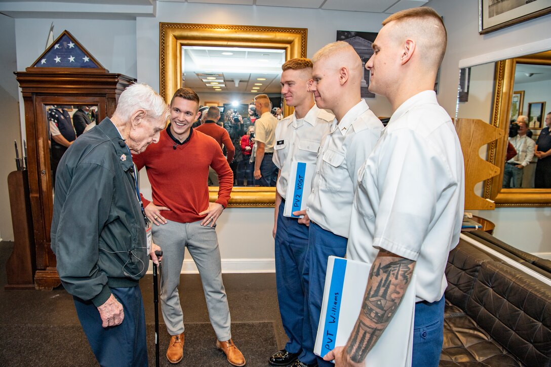 An elderly man speaks to four soldiers.