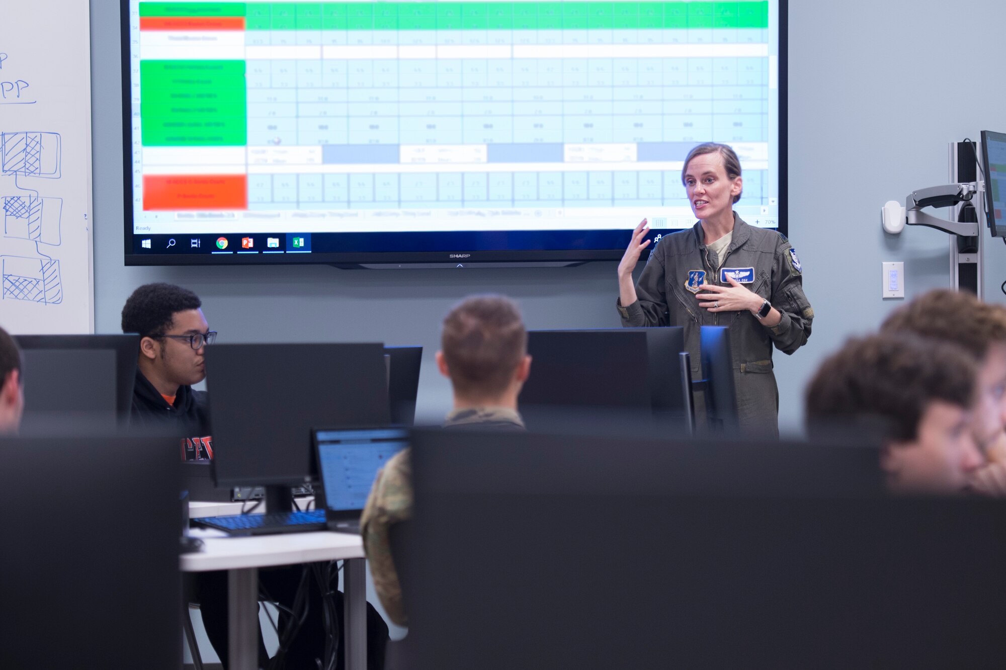 U.S. Air Force Lt. Col. Vanessa Cox, the chief of scheduling with the 116th Operations Support Squadron, Georgia Air National Guard, briefs Mercer University upperclassmen to explain scheduling processes of the E-8C Joint STARS at the Mercer campus in Macon, Ga., Oct. 8, 2019. The students from the computer science department worked on an innovation project to help reform the way JSTARS scheduling is run.