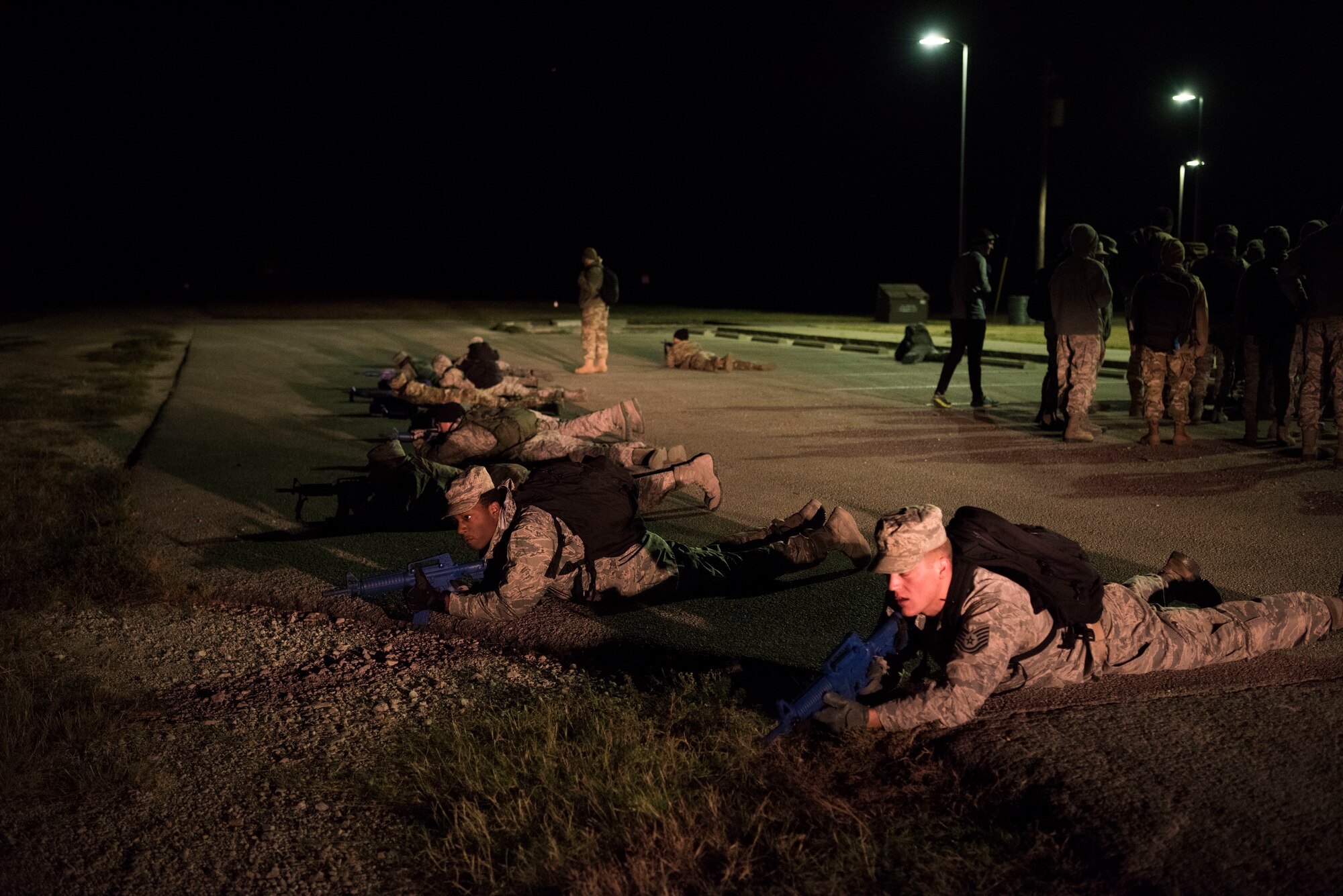 Airmen assigned to the 47th Medical Group lay in a formation to protect against adversaries in an exercise at Laughlin Air Force Base, Texas, Oct. 25, 2019. One aspect the team trained on was setting up 360 degree perimeter security to protect anyone giving medical care from adversaries. (U.S. Air Force photo by Senior Airman Marco A. Gomez)