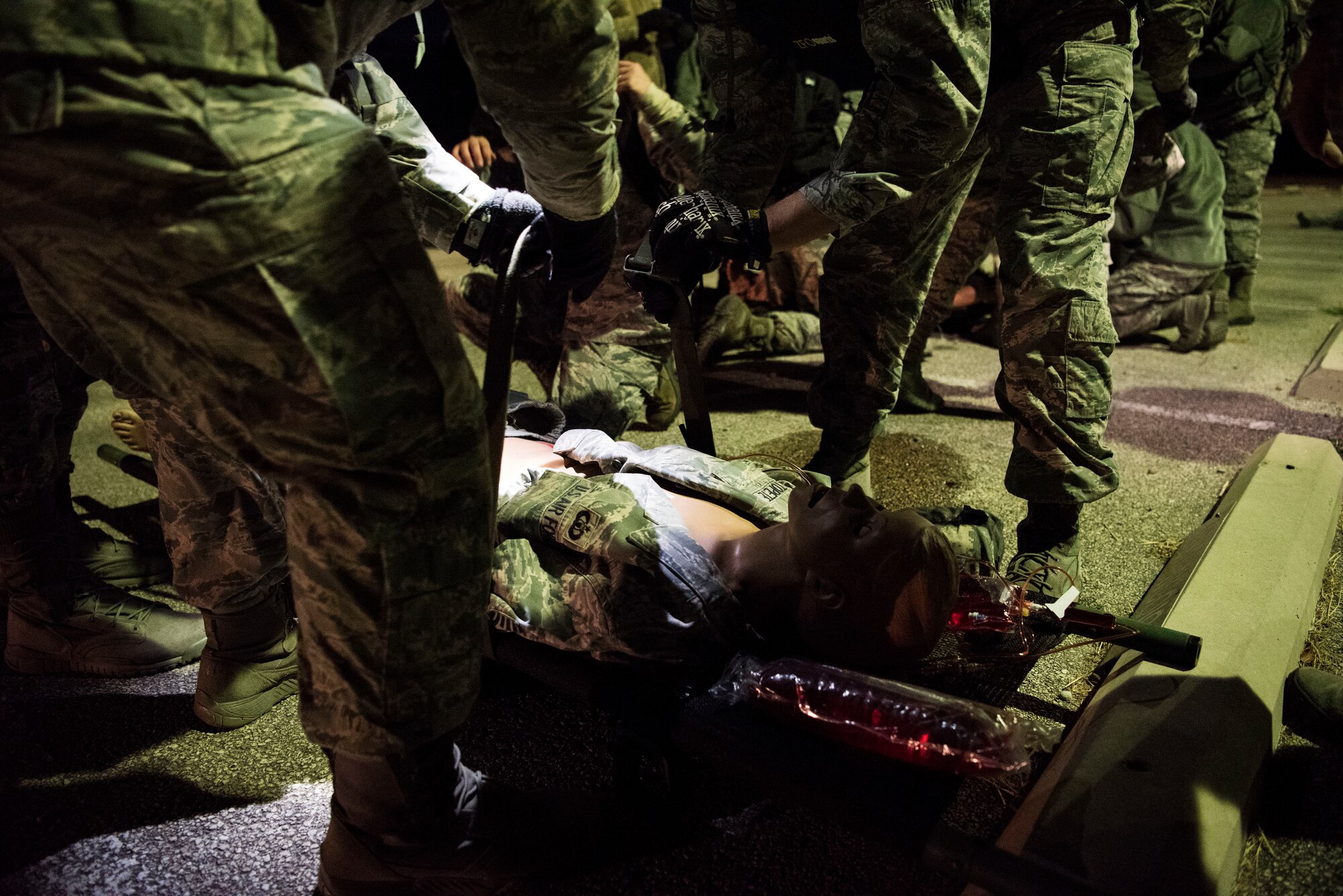 A team of Airmen assigned to the 47th Operational Medical Readiness Squadron strap down an individual for extract during a readiness training exercise at Laughlin Air Force Base, Texas, Oct. 25, 2019. Medical dummies were treated as real casualties while medics had to think critically and act quickly. (U.S. Air Force photo by Senior Airman Marco A. Gomez)