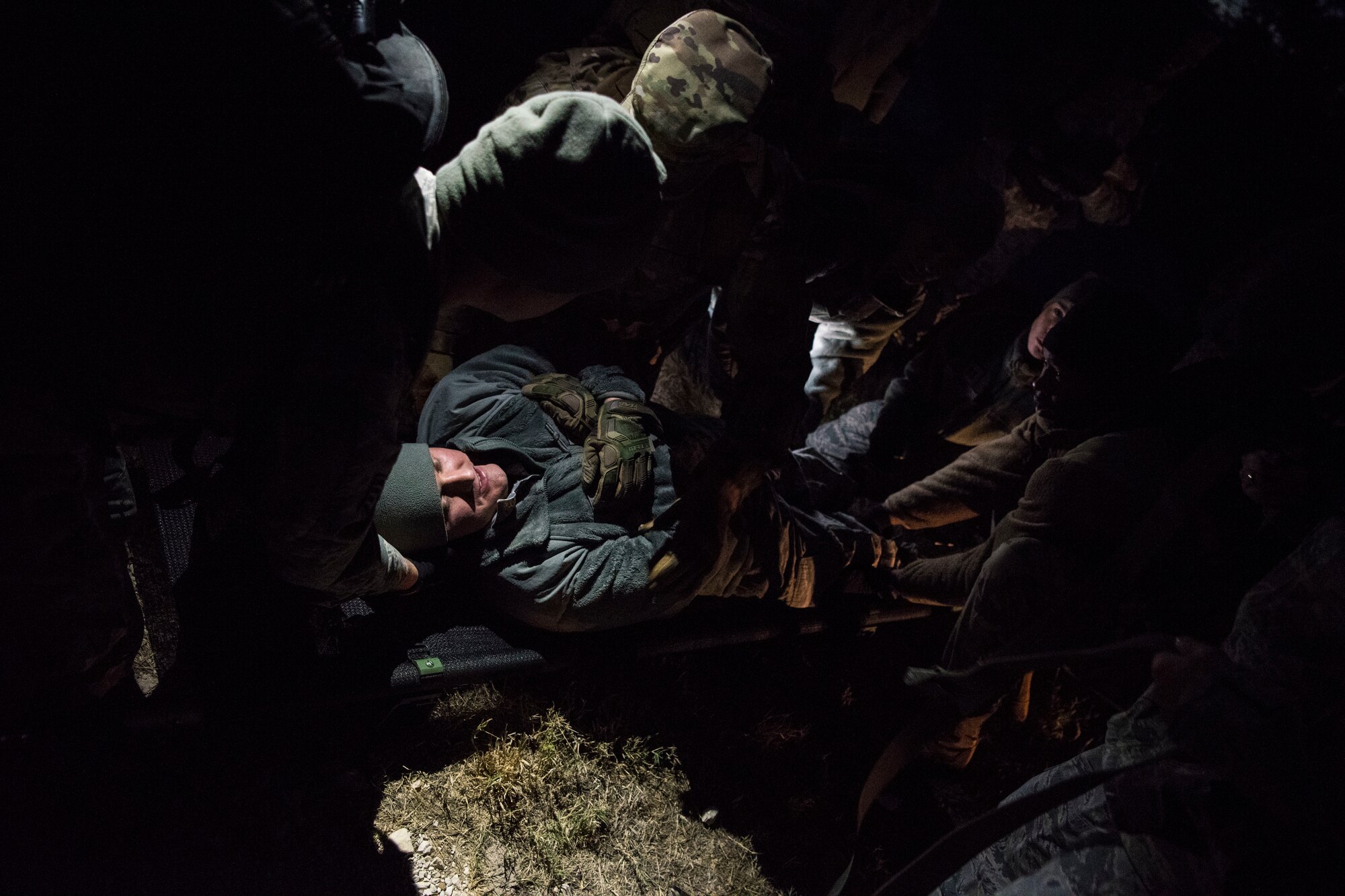 A team of Airmen assigned to the 47th Operational Medical Readiness Squadron lift an injured Airman during a readiness training exercise at Laughlin Air Force Base, Texas, Oct. 25, 2019. Medical dummies as well as one Airmen played the role of being a casualty to simulate real world scenarios as teams of Medics practiced their life saving skills. (U.S. Air Force photo by Senior Airman Marco A. Gomez)