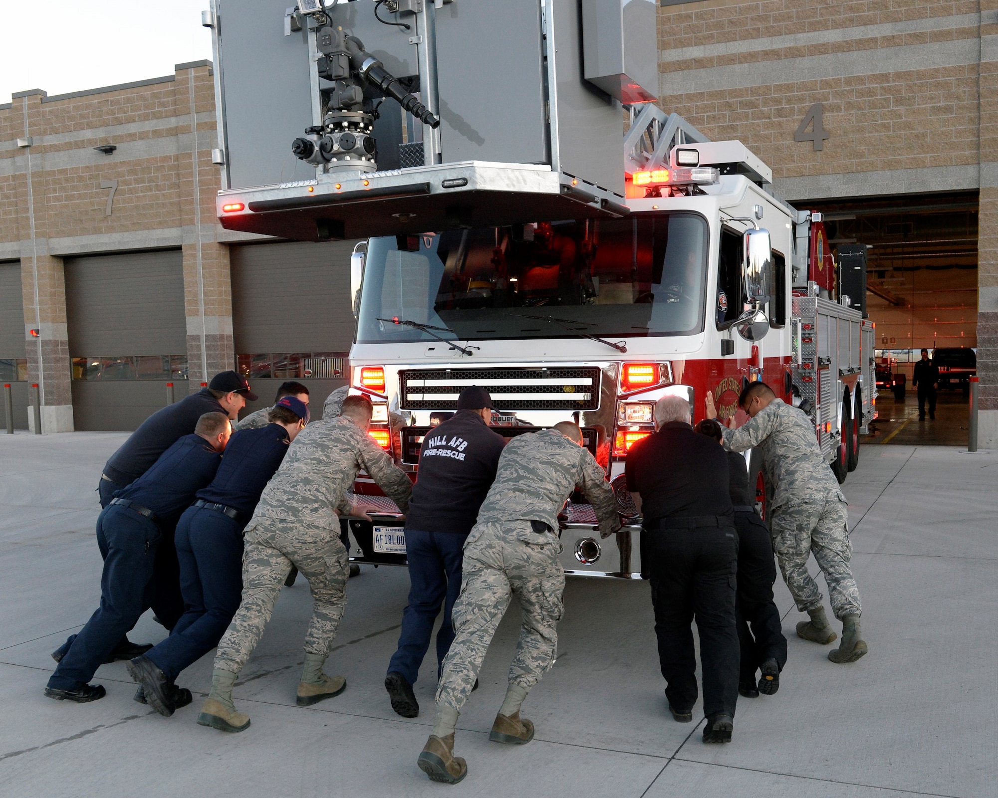 Firefighters push a new fire truck, Truck 101, into Fire Station 1 during a “wet/wash down and push in” ceremony Oct. 24, 2019, at Hill Air Force Base, Utah. The custom dates back to the 1800s when fire engines were pulled by horses. (U.S. Air Force photo by David Perry)