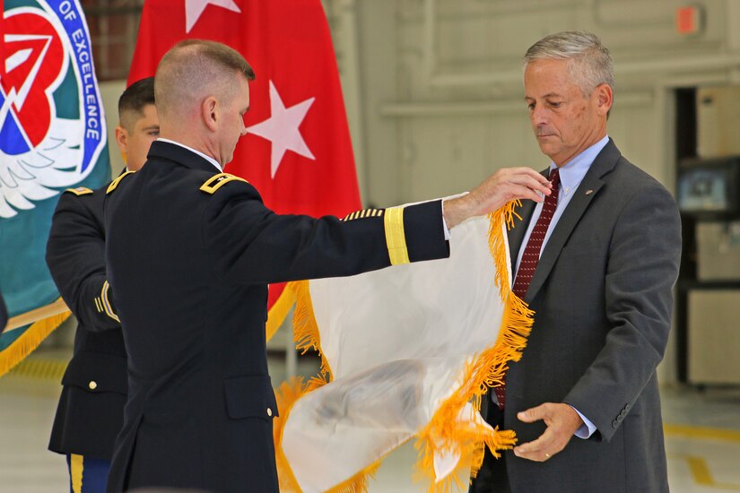 Maj. Gen. Todd Royar, commanding general of the of the U.S. Army Aviation and Missile Command, presents the Senior Executive Service flag to Geoff Downer, director of the AMCOM’s Special Programs (Aviation), during a SES appointment ceremony Oct. 18 at Joint Base Langley-Eustis, Virginia.