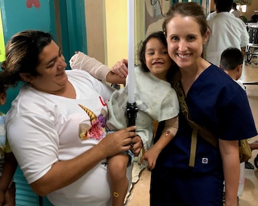 Air Force Maj. Julia Nuelle, chief of Orthopaedic Hand and Microvascular Surgery at Brooke Army Medical Center, poses for a photo with a pediatric patient and her mother Sept. 26 during a Medical Readiness Exercise in Tegucigalpa, Honduras. The team finished their mission by visiting their patients and delivering toys and coloring books to the hospital’s pediatric ward. A team of 19 military medical personnel from Brooke Army Medical Center and other military treatment facilities completed 128 procedures from Sept. 14-27.