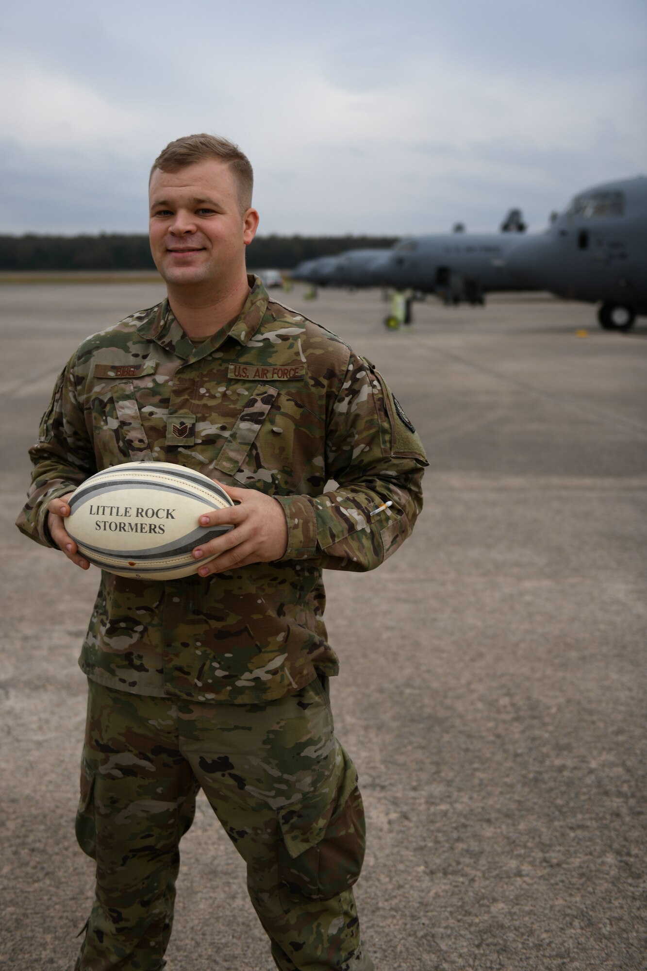 Man stands in front of a C-130J wearing OCPs.