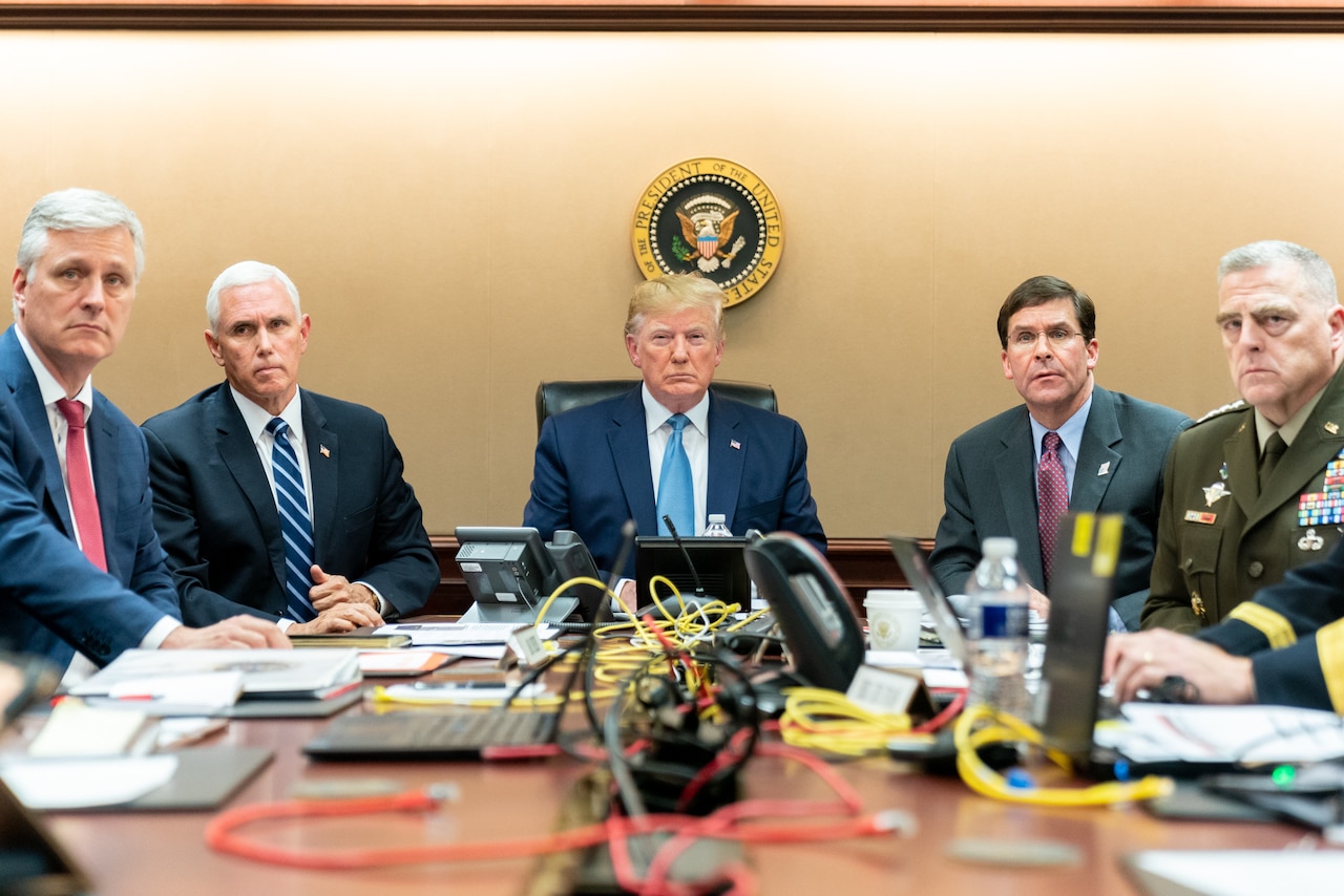 The president and vice president watch a monitor in the White House situation room with military and civilian advisors.