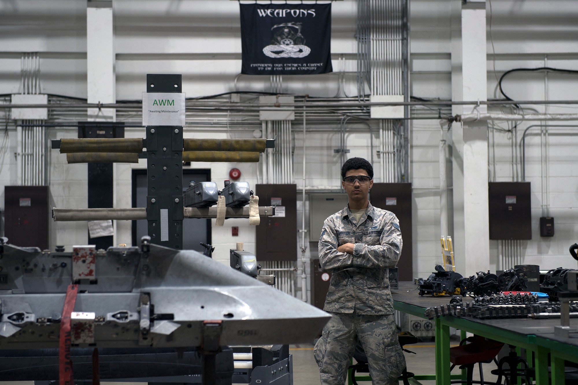 Senior Airman Jordan Harrison, 51st Munitions Squadron F-16 armament systems technician, poses under a weapons banner Oct. 23, 2019, at Osan Air Base, Republic of Korea. (U.S. Air Force photo by Staff Sgt. Gregory Nash)