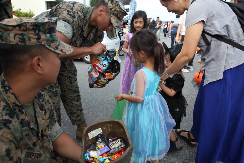 子どもたちにお菓子を配る海兵隊員。キャンプ・シュワブでは10月26日（土）、一足早いハロウィーン・パーティがＵＳＯ（米国慰問団）で開催され、200人以上の海兵隊のボランティアと400人以上の地元の親子が会場を埋め尽くしました。