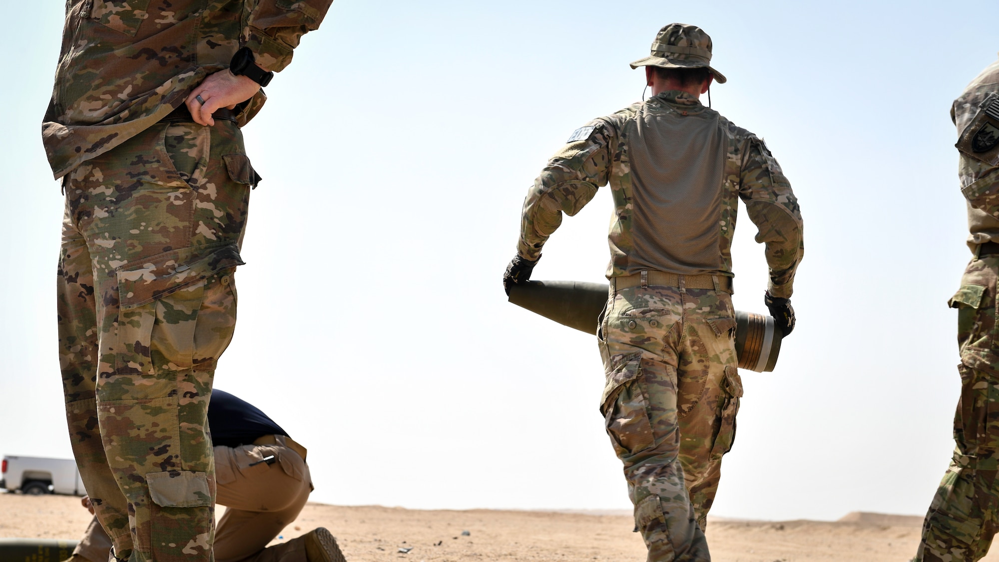 U.S. Army Sgt. 1st Class Jesse Harris, 744th Ordnance Company operations sergeant, carries a 155MM insensitive high explosive round before a munitions disposal training at the Udari Range, Kuwait, Sept. 30, 2019. The training was designed to demonstrate proper insensitive munitions disposal by using C-4 high explosives to properly detonate and consume the 155MM artillery round.