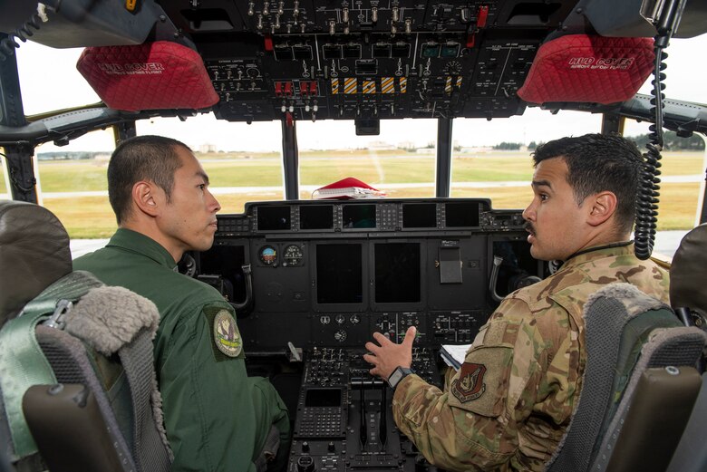 Staff Sgt. Hector Frietze, 36th Airlift Squadron loadmaster, explains how they perform pre-flight inspections inside a C-130J Super Hercules to Koku-Jieitai Tech. Sgt. Hideki Tanaka, 403rd Tactical Airlift Squadron loadmaster assigned with Miho Air Base, Japan, Oct. 22, 2019, at Yokota Air Base.