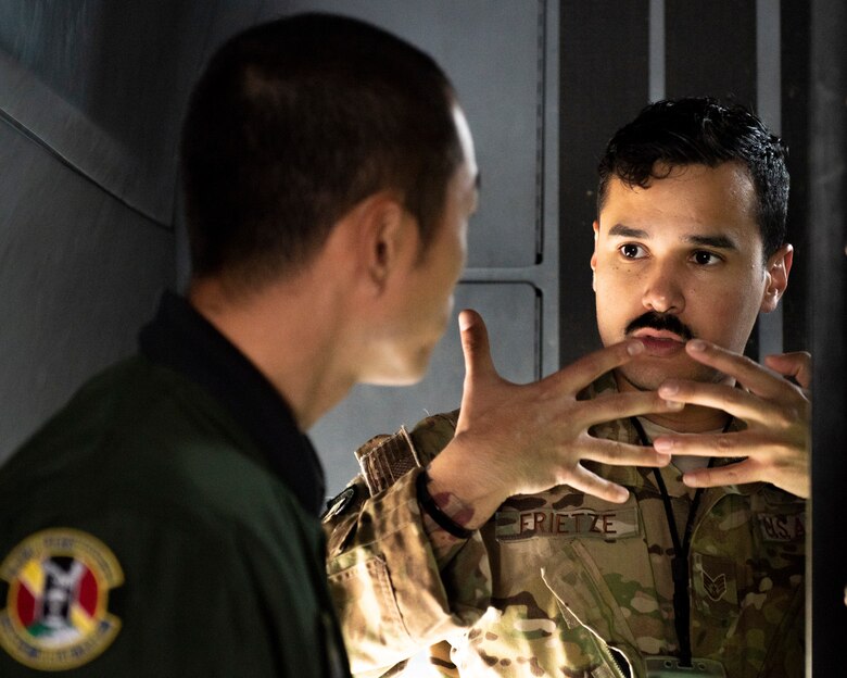 Staff Sgt. Hector Frietze, 36th Airlift Squadron loadmaster, explains a multi-function color display installed in C-130J Super Hercules to Koku-Jieitai Tech. Sgt. Hideki Tanaka, 403rd Tactical Airlift Squadron loadmaster assigned with Miho Air Base, Japan, during the Bilateral Exchange Program, Oct. 22, 2019, at Yokota Air Base.