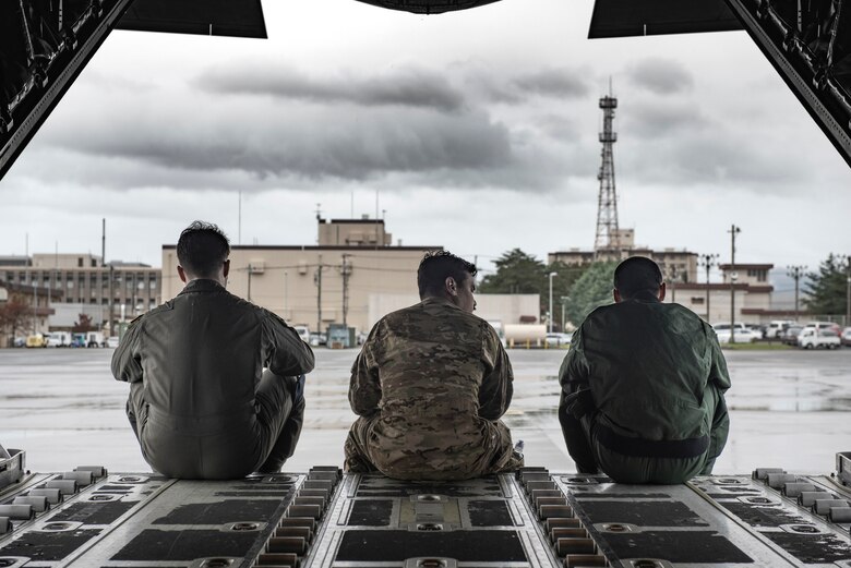Staff Sgt. Hector Frietze, 36th Airlift Squadron loadmaster, talks to Koku-Jieitai Tech. Sgt. Hideki Tanaka, 403rd Tactical Airlift Squadron loadmaster assigned with Miho Air Base, Japan, while they wait for equipment that they will load onto C-130J Super Hercules, Oct. 22, 2019, at Yokota Air Base.