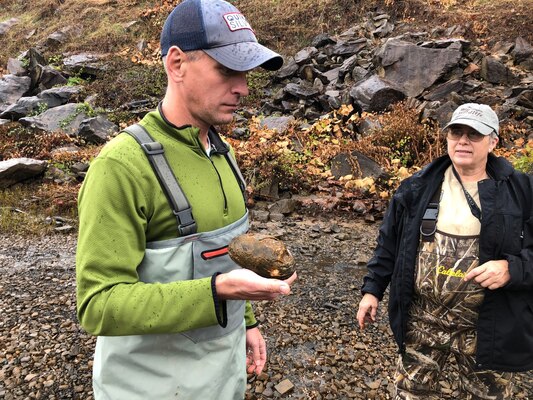 Andrew Johnson relocates a plain pocketbook mussel that was stranded as a result of the receding waters downstream.