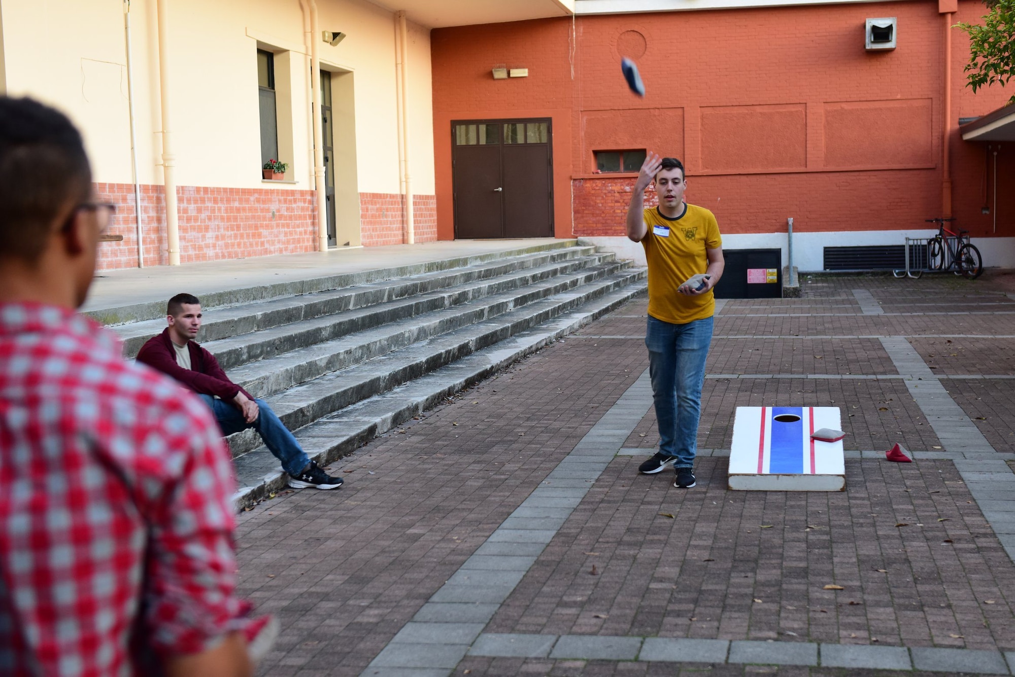 U.S. Airmen play cornhole at the Wyvern Refuge during its re-opening ceremony at Aviano Air Base, Italy, Oct. 25, 2019. The Refuge recently went through more than $17,000 worth of renovation, aimed towards offering Airmen E1 through E4 a place to meet and relax on base. (U.S. Air Force photo by Staff Sgt. Kelsey Tucker)