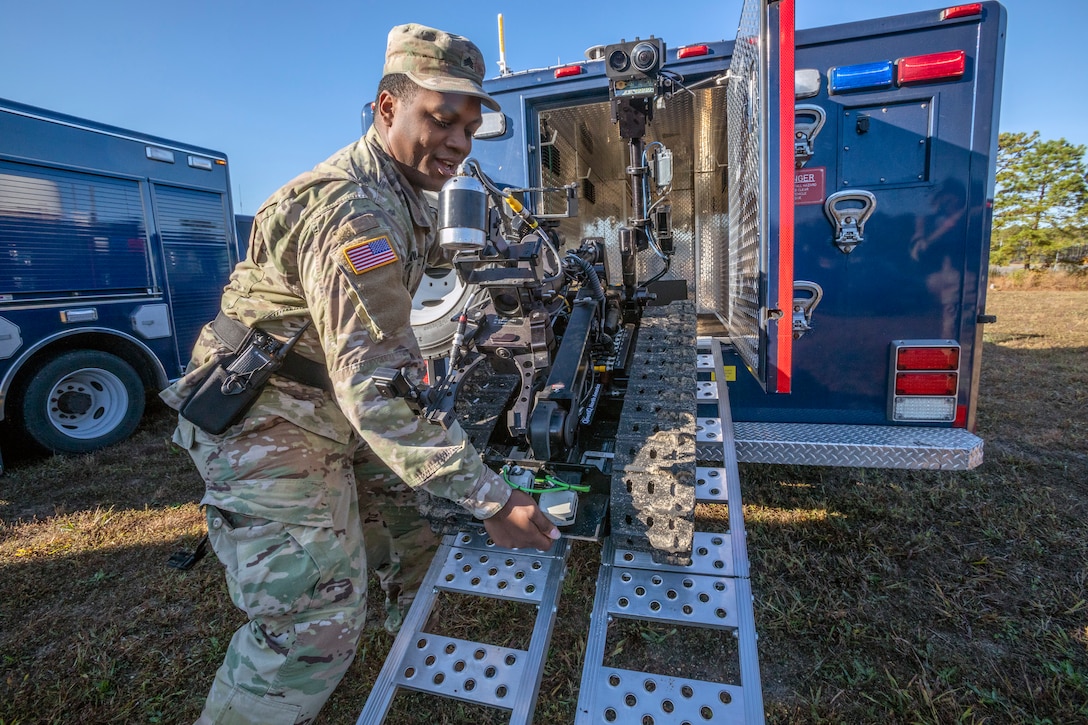 A soldier unloads a robot from a truck.