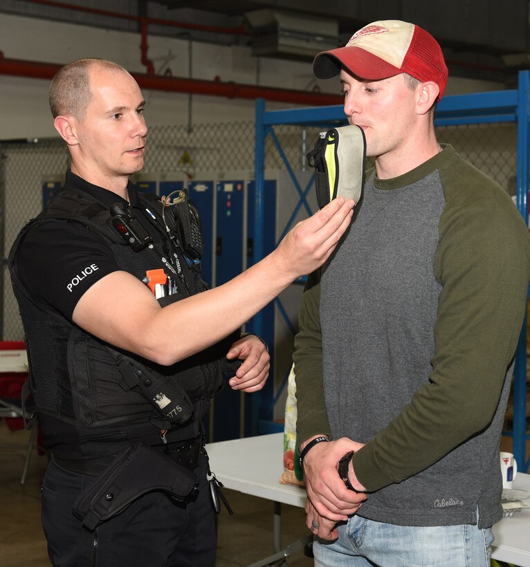 Police Constable Simon Myall, Suffolk Police, breathalyzes an 100th Logistics Readiness Squadron Airman during a controlled drinking experiment as part of a safety awareness event at RAF Mildenhall, Oct. 11, 2019. The event was to focus on the dangers and show consequences of drunk driving, while at the same time promote safe practices for 100th LRS Airmen and civilians in a way other than slide shows.  (U.S. Air Force photo by Karen Abeyasekere)