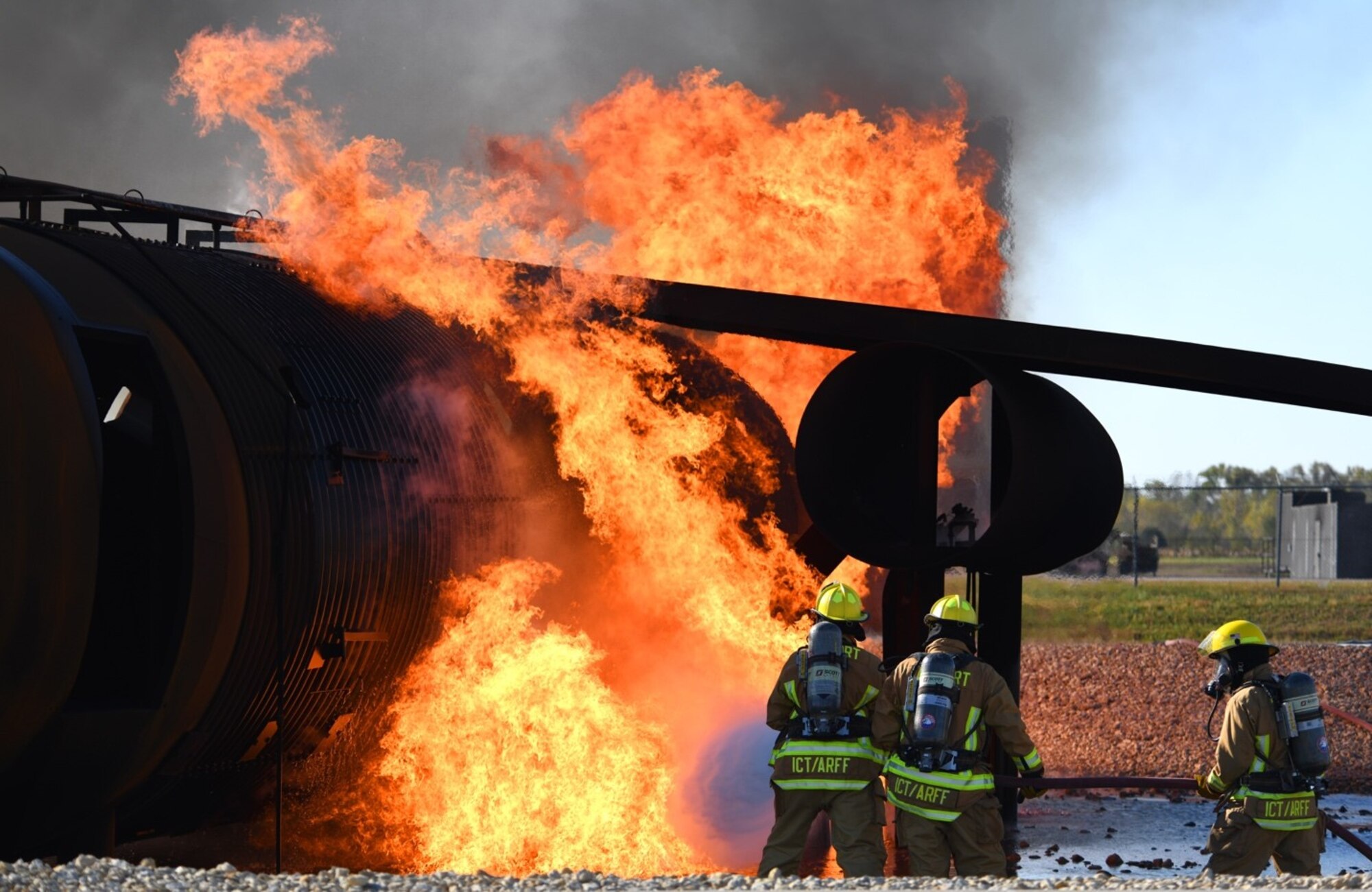 Firefighters from the Wichita Airport Police and Fire Department fight a ground fire on a large frame training aircraft Oct. 21, 2019, at McConnell Air Force Base, Kan. The two-hour training consisted of a total of 10 live simulated fires. (U.S. Air Force photo by Airman 1st Class Nilsa E. Garcia)