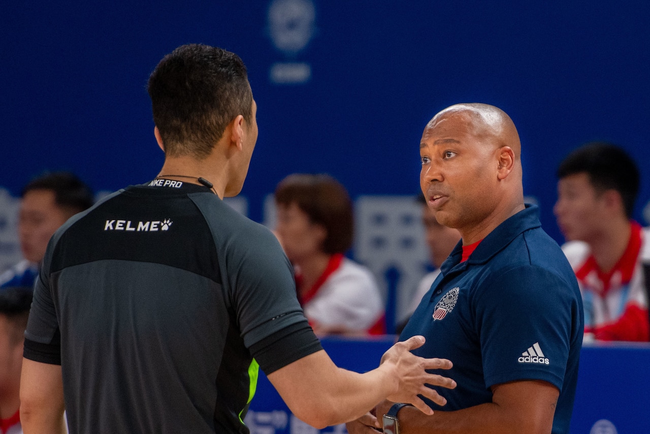 Basketball coach confers with referee.