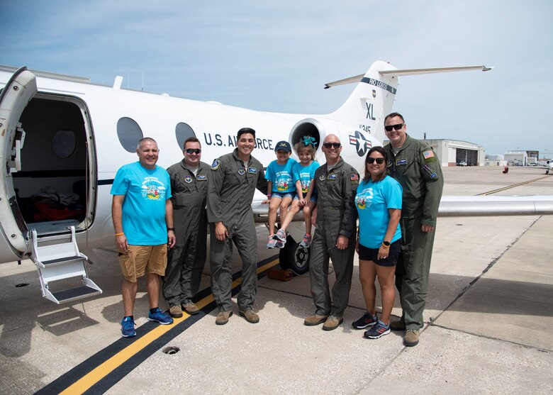 96th Flying Training Squadron T-1 Jayhawk Reserve instructor pilots Maj. Wade Dahlgren and Lt. Col. Doug Hayes (pilots on the right), and 86th Flying Training Squadron regular Air Force teammates Capt. Anthony Giebelhaus and Capt. Roland Kern (pilots on the left) pose with Alessandra "Ale" Alaniz, 100th child selected for the Naval Air Station Corpus Christi Pilot for a Day honors, and Ale's family. (U.S. Air Force photo)