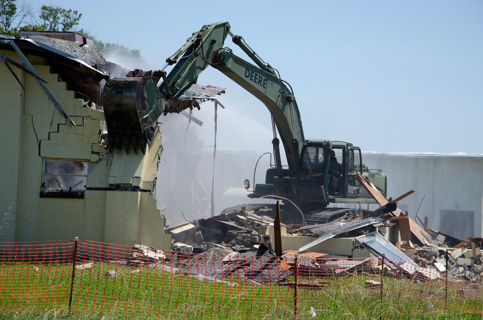 A Georgia Army National Guard Soldier with the 877th Engineer Company, 878th Engineer Battalion, operates an excavator to demolish a building scheduled for demolition at  Fort Benning.