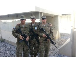 From left to right, Sgt. 1st Class Joseph Howard, Sgt. Michael Howard, motor transport operators, 498th Transportation Company, and Sgt. 1st Class Bryant Howard, motor transport operator, 850th Transportation Company, pose for a photo as Bryant prepares to redeploy back to the U.S. at Kandahar Airfield, April. 28, 2014. (Courtesy photo)