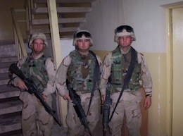 From left to right - Spc. Bryant Howard, Spc. Berry Terrell, and Spc. Joseph Howard, motor transport operators, 498th Transportation Company, stand ready in preparation of a convoy at Camp Speicher, Iraq, Jun. 28, 2003. (Courtesy photo)