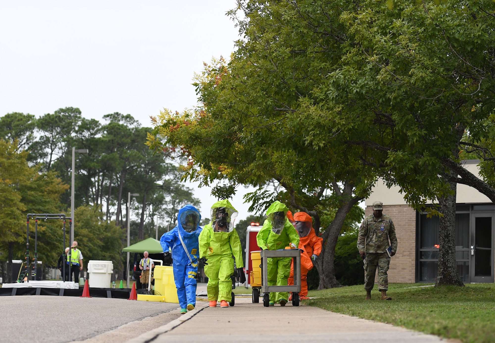 Members of the Keesler fire department, bioenvironmental and emergency management make their way to the scene for testing a simulated biological agent during the Anti-Terrorism, Force Protection Condition and Chemical, Biological, Radiological, Nuclear and high-yield Explosives training exercise near the Live Oak Dining Facility at Keesler Air Force Base, Mississippi, Oct. 24, 2019. The exercise scenario simulated a gym bag with ricin found by Keesler personnel who alerted first responders. The exercise was conducted to evaluate the mission readiness and security of Keesler. (U.S. Air Force photo by Kemberly Groue)