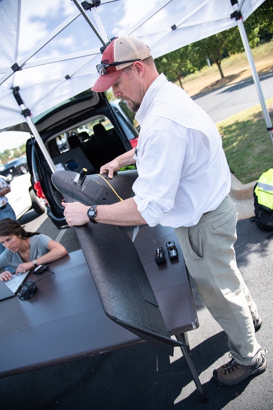 Ryan Strange, a research physical scientist with the U.S. Army Corps of Engineers’ Aviation and Remote Systems Program and Huntsville Center’s Unmanned Aircraft Systems Site Development Branch, assembles the senseFly eBee X fixed-wing unmanned aircraft system outside the U.S. Army Engineering and Support Center, Huntsville, Alabama, Oct. 1, 2019, in preparation for flight. At left is Bethanie Thomas, a civil engineer with Huntsville Center’s Unmanned Aircraft Systems Site Development Branch, who is double-checking programmed flight-plan characteristics before takeoff, such as altitude, ground speed, mission waypoints and flight time.