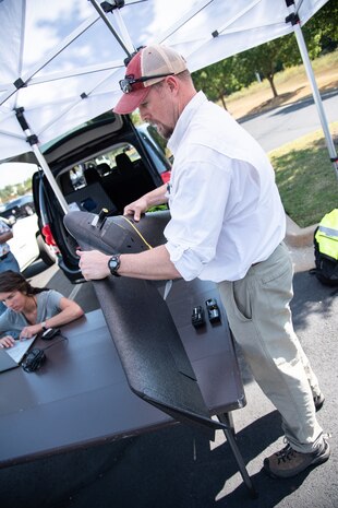 Ryan Strange, a research physical scientist with the U.S. Army Corps of Engineers’ Aviation and Remote Systems Program and Huntsville Center’s Unmanned Aircraft Systems Site Development Branch, assembles the senseFly eBee X fixed-wing unmanned aircraft system outside the U.S. Army Engineering and Support Center, Huntsville, Alabama, Oct. 1, 2019, in preparation for flight. At left is Bethanie Thomas, a civil engineer with Huntsville Center’s Unmanned Aircraft Systems Site Development Branch, who is double-checking programmed flight-plan characteristics before takeoff, such as altitude, ground speed, mission waypoints and flight time.