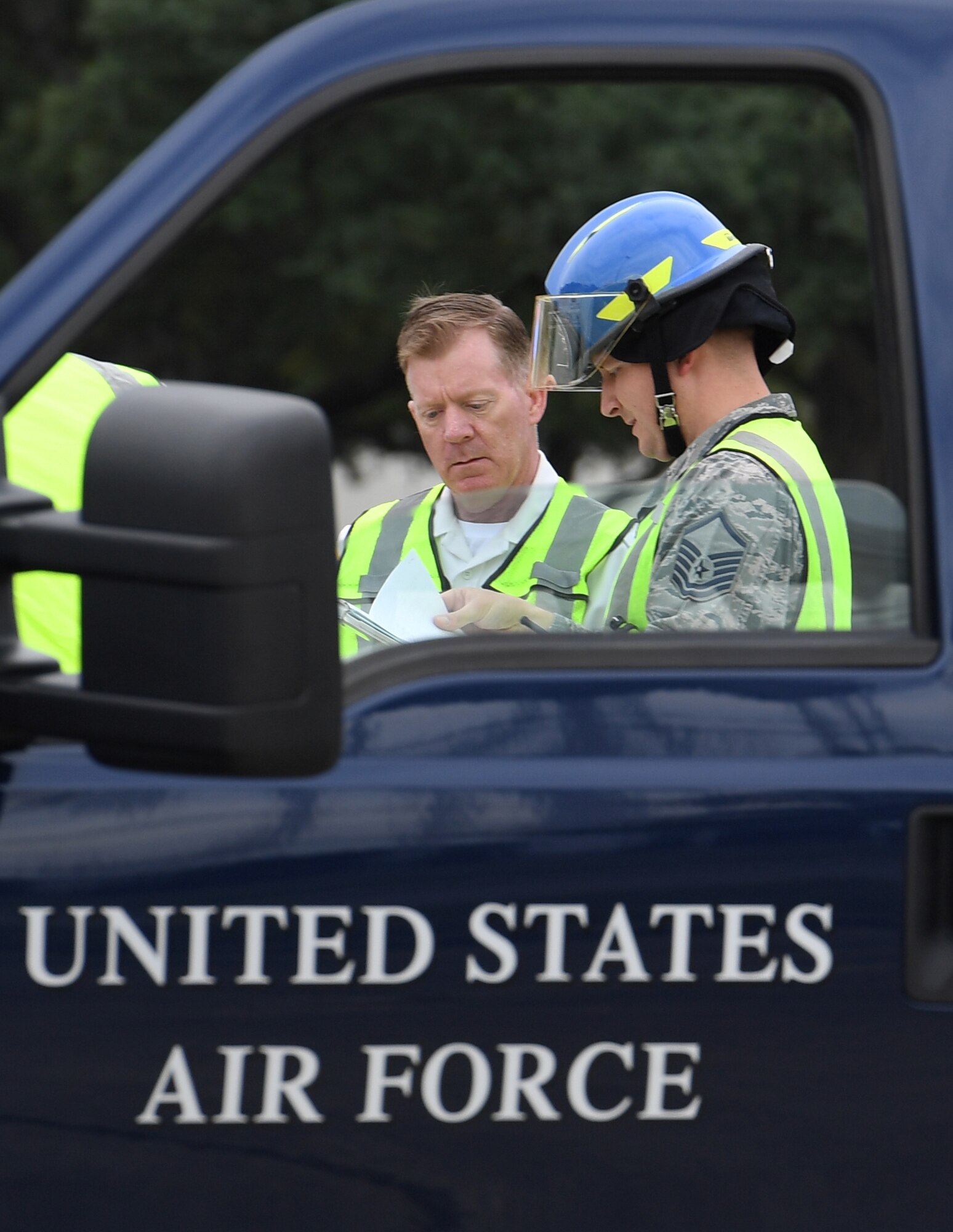 Gary Pierson, 81st Infrastructure Division deputy fire chief, and U.S. Air Force Master Sgt. Daniyel Blankenship, 81st ID firefighter, review the site safety plan for firefighters during the Anti-Terrorism, Force Protection Condition and Chemical, Biological, Radiological, Nuclear and high-yield Explosives training exercise near the Live Oak Dining Facility at Keesler Air Force Base, Mississippi, Oct. 24, 2019. The exercise scenario simulated a gym bag with ricin found by Keesler personnel who alerted first responders. The exercise was conducted to evaluate the mission readiness and security of Keesler. (U.S. Air Force photo by Kemberly Groue)
