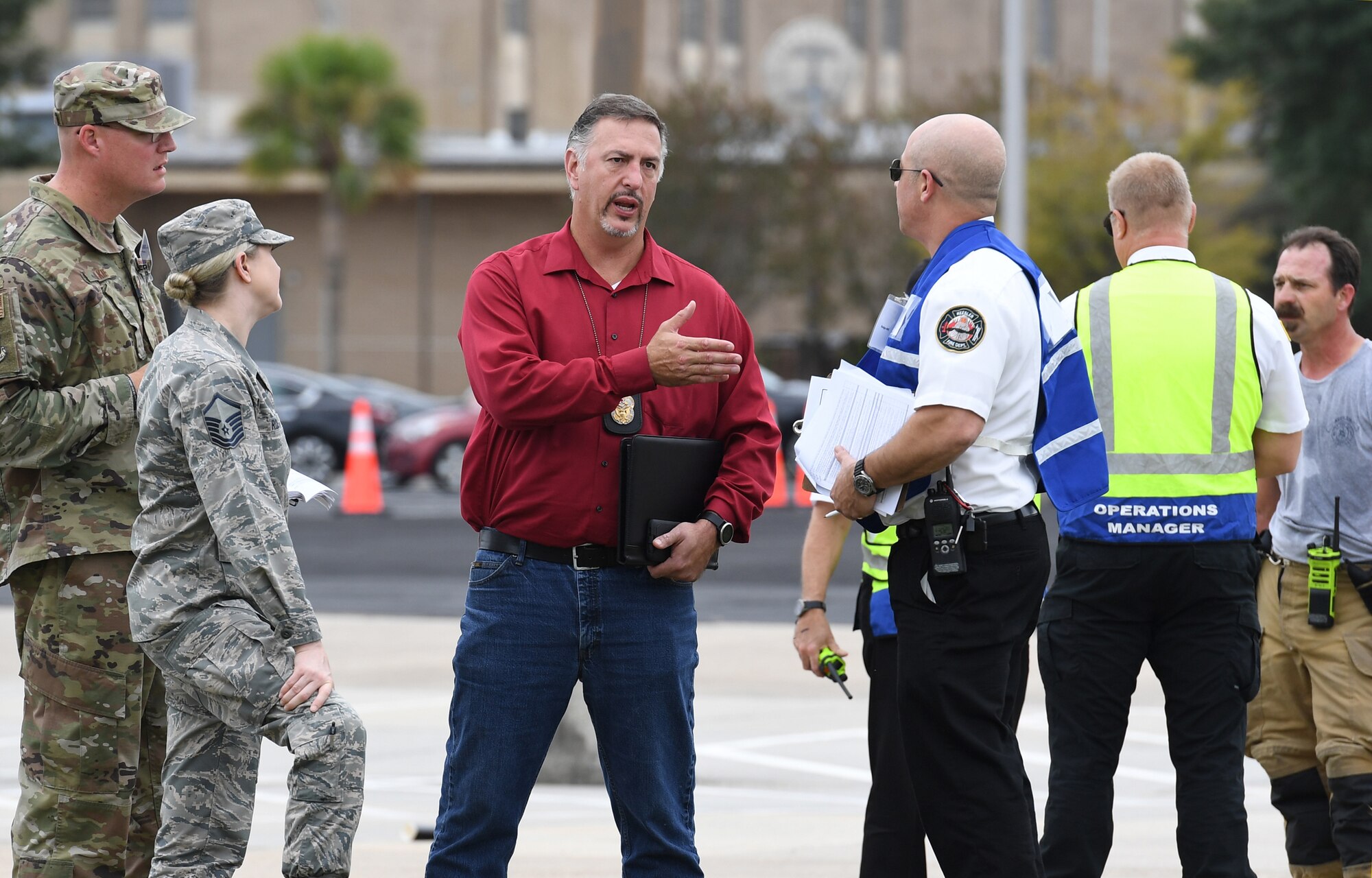 Bill Mays, 81st Training Wing wing inspection team lead, speaks with inspection team members during the Anti-Terrorism, Force Protection Condition and Chemical, Biological, Radiological, Nuclear and high-yield Explosives training exercise near the Live Oak Dining Facility at Keesler Air Force Base, Mississippi, Oct. 24, 2019. The exercise scenario simulated a gym bag with ricin found by Keesler personnel who alerted first responders. The exercise was conducted to evaluate the mission readiness and security of Keesler. (U.S. Air Force photo by Kemberly Groue)