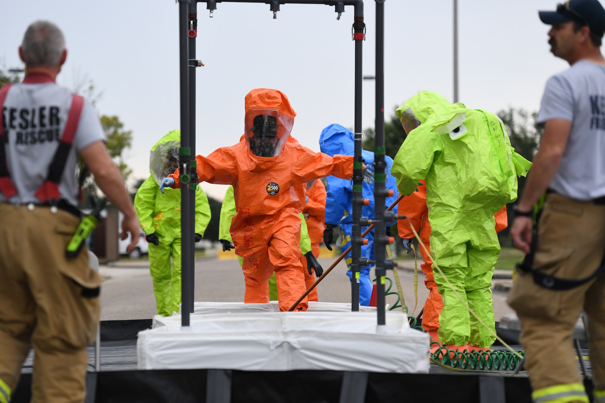 Members of the Keesler fire department, bioenvironmental and emergency management go through the decontamination site during the Anti-Terrorism, Force Protection Condition and Chemical, Biological, Radiological, Nuclear and high-yield Explosives training exercise near the Live Oak Dining Facility at Keesler Air Force Base, Mississippi, Oct. 24, 2019. The exercise scenario simulated a gym bag with ricin found by Keesler personnel who alerted first responders. The exercise was conducted to evaluate the mission readiness and security of Keesler. (U.S. Air Force photo by Kemberly Groue)
