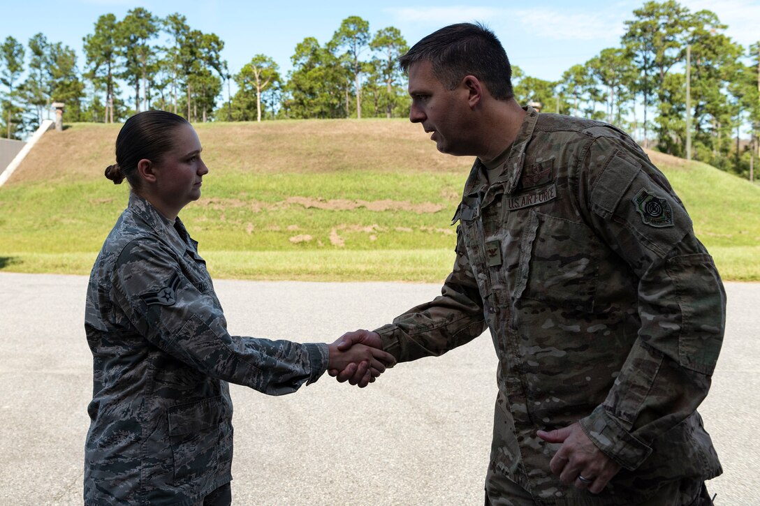 Col. Dan Walls, right, 23d Wing commander, coins Airman 1st Class Lindlie Rabe, 23d Maintenance Squadron (MXS) stockpile management technician, during an immersion tour Oct. 28, 2019, at Moody Air Force Base, Ga. Walls toured the 23d MXS munitions flight facilities, where the Airmen showcased their squadron and mission. This gave Walls the opportunity to see how 23d MXS improves deployability and ensures mission readiness. (U.S. Air Force photo by Senior Airman Erick Requadt)
