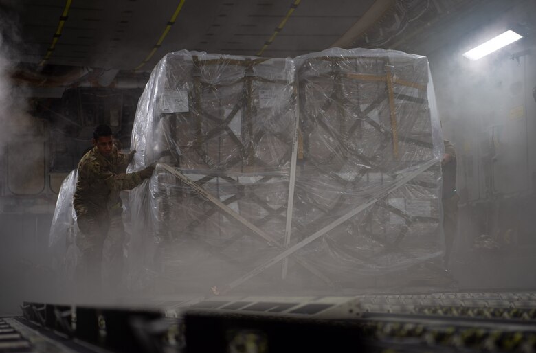 U.S Air Force Staff Sgt. Marcello Moffat, 8th Airlift Squadron loadmaster, helps push a pallet containing rice off a C-17 Globemaster III assigned to the 62nd Airlift Wing, Joint Base Lewis-McChord, Wash., at Soto Cano Air Base, Honduras, Oct. 24, 2019. Almost $120,000 worth of rice was donated to help feed Honduran men, women and children. (U.S Air Force photo by Senior Airman Tryphena Mayhugh)