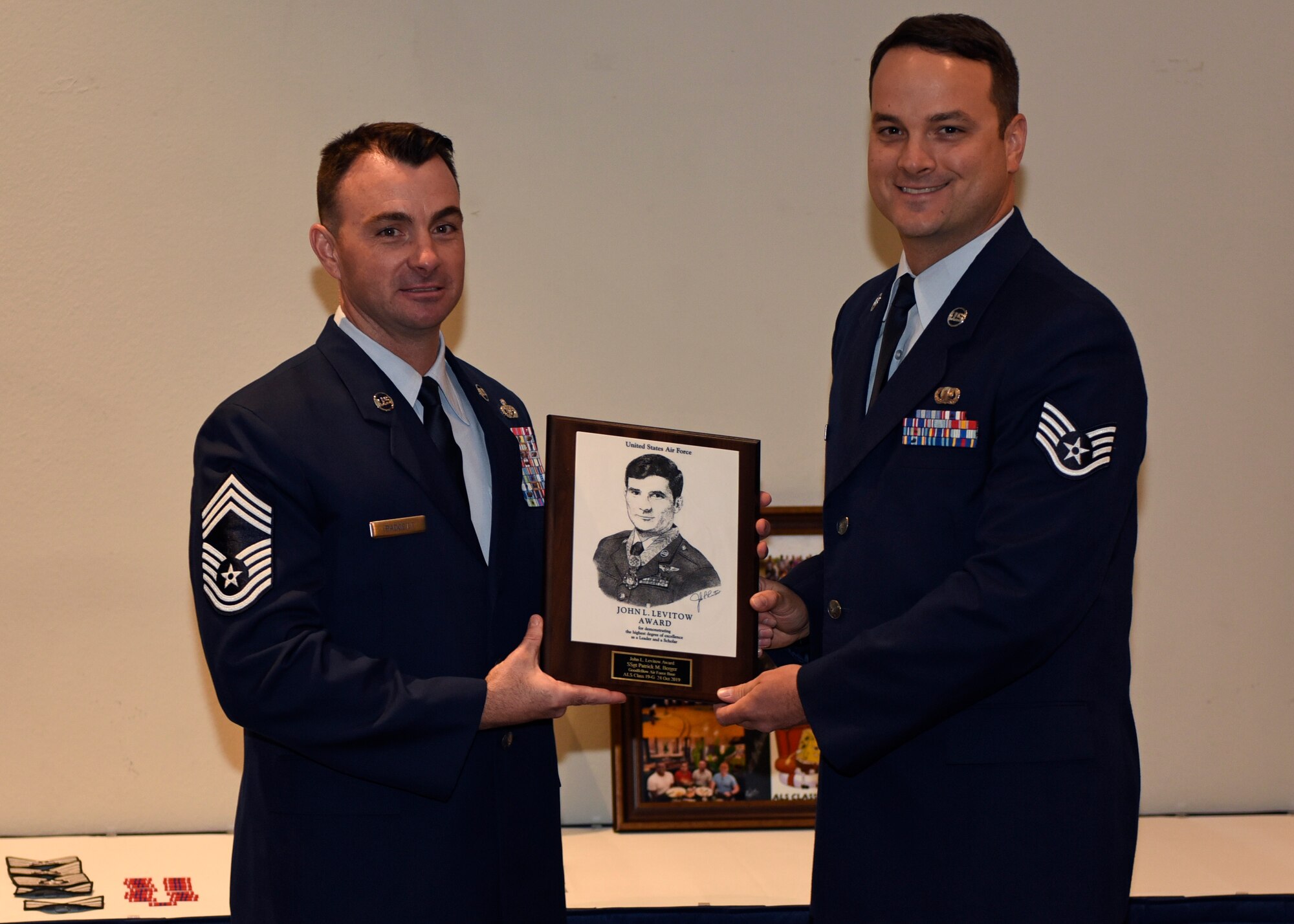 U.S. Air Force Chief Master Sgt. Michael Padgett, 17th Mission Support Group superintendent, presents the John L. Levitow Award to Staff Sgt. Patrick Berger, 17th Contracting Squadron contracting specialist, at the event center on Goodfellow Air Force Base, Texas, Oct. 24, 2019. The John L. Levitow Award is the highest award possible in professional military education, it is based upon all performance tasks, peer stratifications, and the capstone exercise. (U.S. Air Force photo by Airman 1st Class Ethan Sherwood/Released)