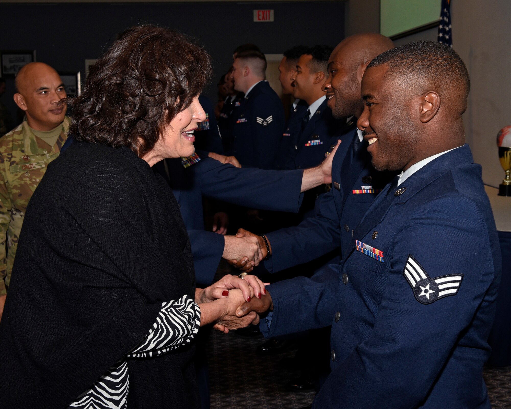 The sister of Medal of Honor recipient Capt. Lance P. Sijan, Janine Sijan, congratulates Airman Leadership School Class 19-G at the event center on Goodfellow Air Force Base, Texas, Oct. 24, 2019. The four-week course was designed to shape today’s Airmen into tomorrow’s leaders. (U.S. Air Force photo by Airman 1st Class Ethan Sherwood/Released)