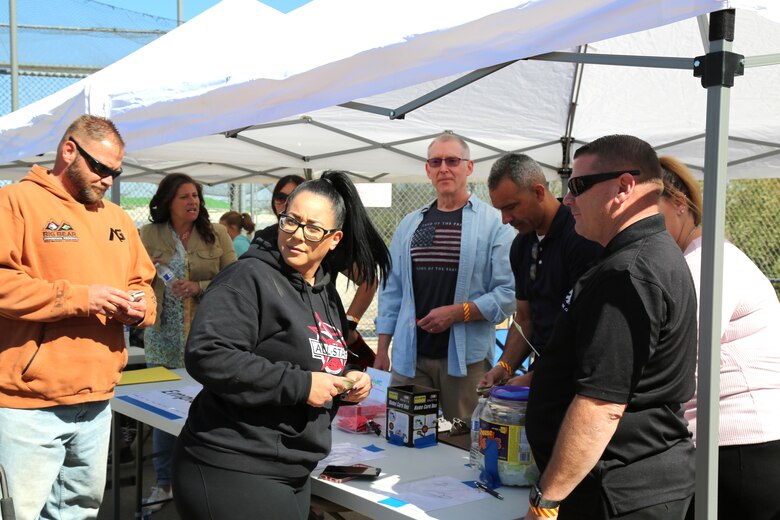Robert “Chip” Schwartz, Plant Manager, Production Plant Barstow, Marine Depot Maintenance Command aboard Marine Corps Logistics Base Barstow, ensures attendees get their tickets into various drawings during the Employee Recognition Day celebration held at the Robert A. Sessions Memorial Sportspark, Barstow, California, Oct. 12.