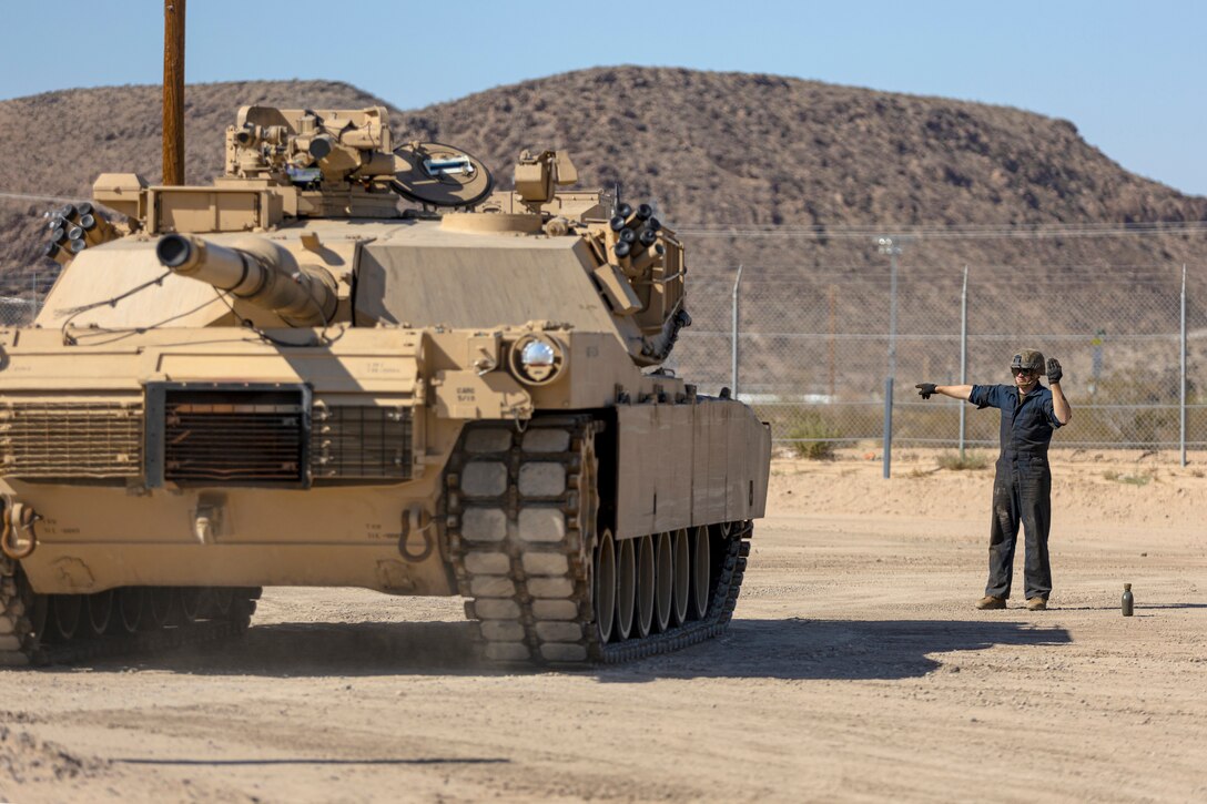Corporal Melvin Golden, motor vehicle operator, ground guides a M1A1 Abrams Main Battle Tank during offload procedures of Second Marine Division’s assets aboard the Yermo Annex of Marine Corps Logistics Base Barstow, Calif., Sept. 27. The Marine vehicles will be transported by truck to Marine Corps Air-Ground Combat Center, 29 Palms, Calif.,to engage in a four day training exercise.