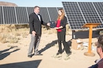 (Left) Steven Smith, vice president, Energy Systems Group; presents Alicia Florez, Engineering Manager, Production Plant Barstow, Marine Depot Maintenance Command; with a plaque thanking her for her part in getting the10-acre solar photo voltaic installation aboard the Yermo Annex up and going. The solar farm was officially opened when Col. Craig Clemans, commanding officer, Marine Corps Logistics Base Barstow, Calif., cut the ribbon on the project Oct. 22. The new solar project is expected to save the base $26,000,000 over the 22-year life of the contract with ESG