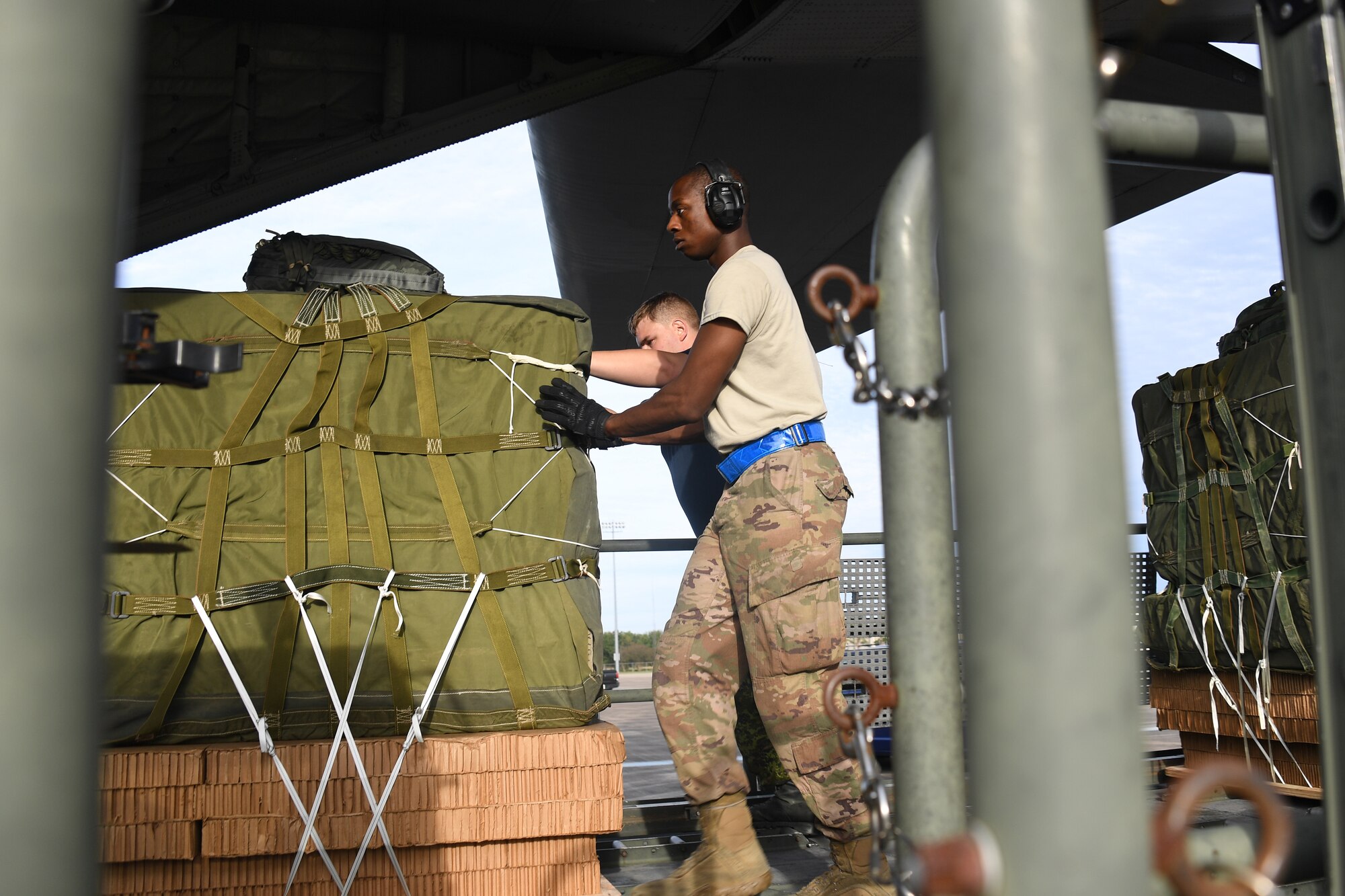 U.S. Air Force Airman 1st Class Ernest Washington, 821st Contingency Response Support Squadron aerial porter, pushes cargo onto a Royal Canadian Air Force C-130 aircraft during exercise Green Flag Little Rock, Oct. 24, 2019, Alexandria International Airport, Louisiana. During the exercise the team loaded and downloaded tactical vehicles, airdrop bundles, along with a variety of other pallets to support the Army. (U.S. Air Force photo by Tech. Sgt. Liliana Moreno)