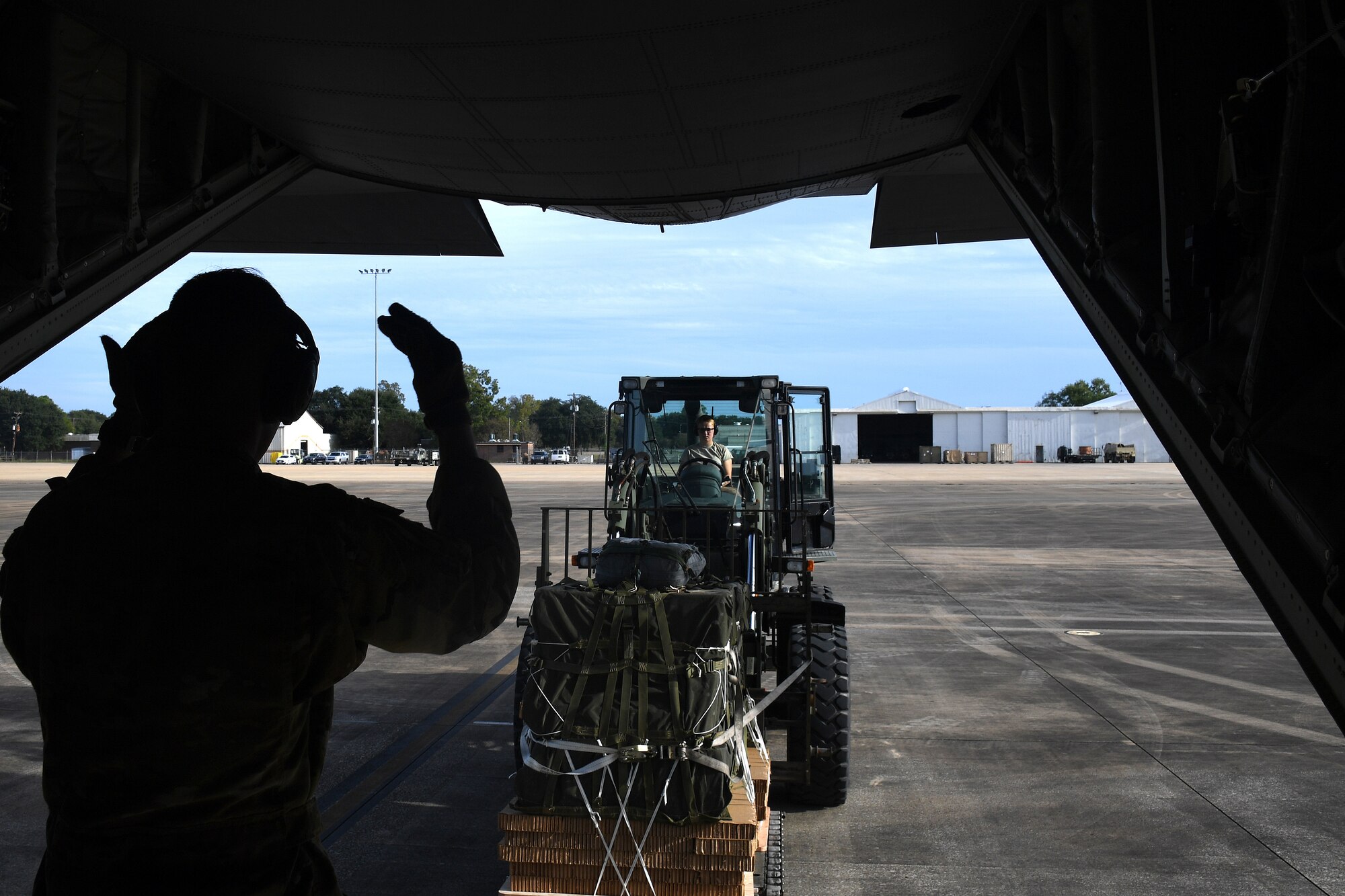 U.S. Air Force Airman 1st Class Elizaveta Woodcock, 321st Contingency Response Squadron aerial porter, moves cargo onto a U.S Air Force C-130 aircraft during exercise Green Flag Little Rock, Oct. 24, 2019, Alexandria International Airport, Louisiana. During the exercise the team loaded and downloaded tactical vehicles, airdrop bundles, along with a variety of other pallets to support the Army. (U.S. Air Force photo by Tech. Sgt. Liliana Moreno)