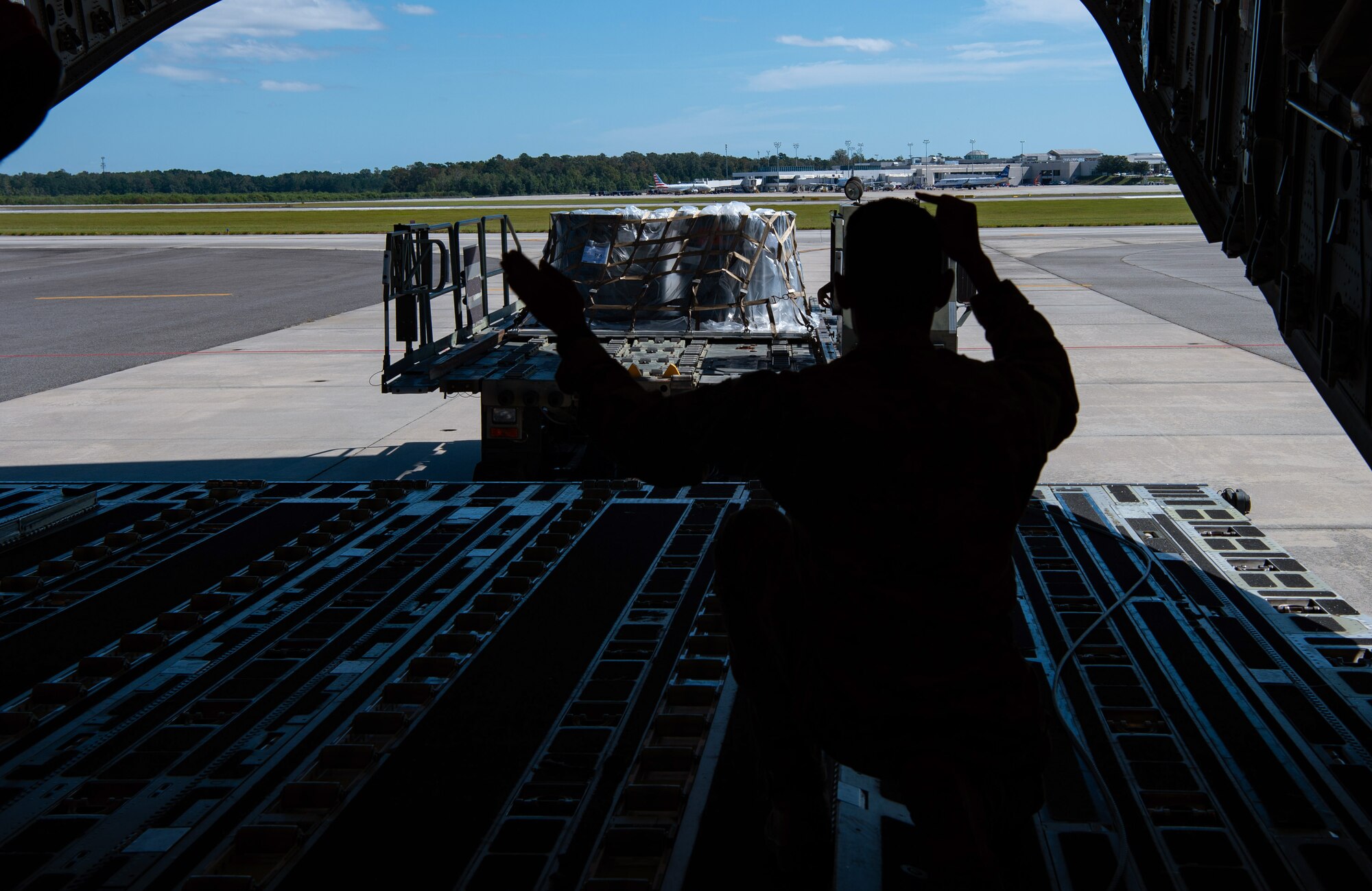 U.S. Air Force Staff Sgt. Marcello Moffat, 8th Airlift Squadron (AS) loadmaster, marshals a 1,000-pound loader toward a C-17 Globemaster III assigned to the 62nd Airlift Wing, Joint Base Lewis-McChord, Wash., at Altus Air Force Base, Okla., Oct. 24, 2019. Moffat and other 8th AS Airmen delivered more than 83,000 pounds of rice to Honduras for a humanitarian mission. (U.S Air Force photo by Senior Airman Tryphena Mayhugh)