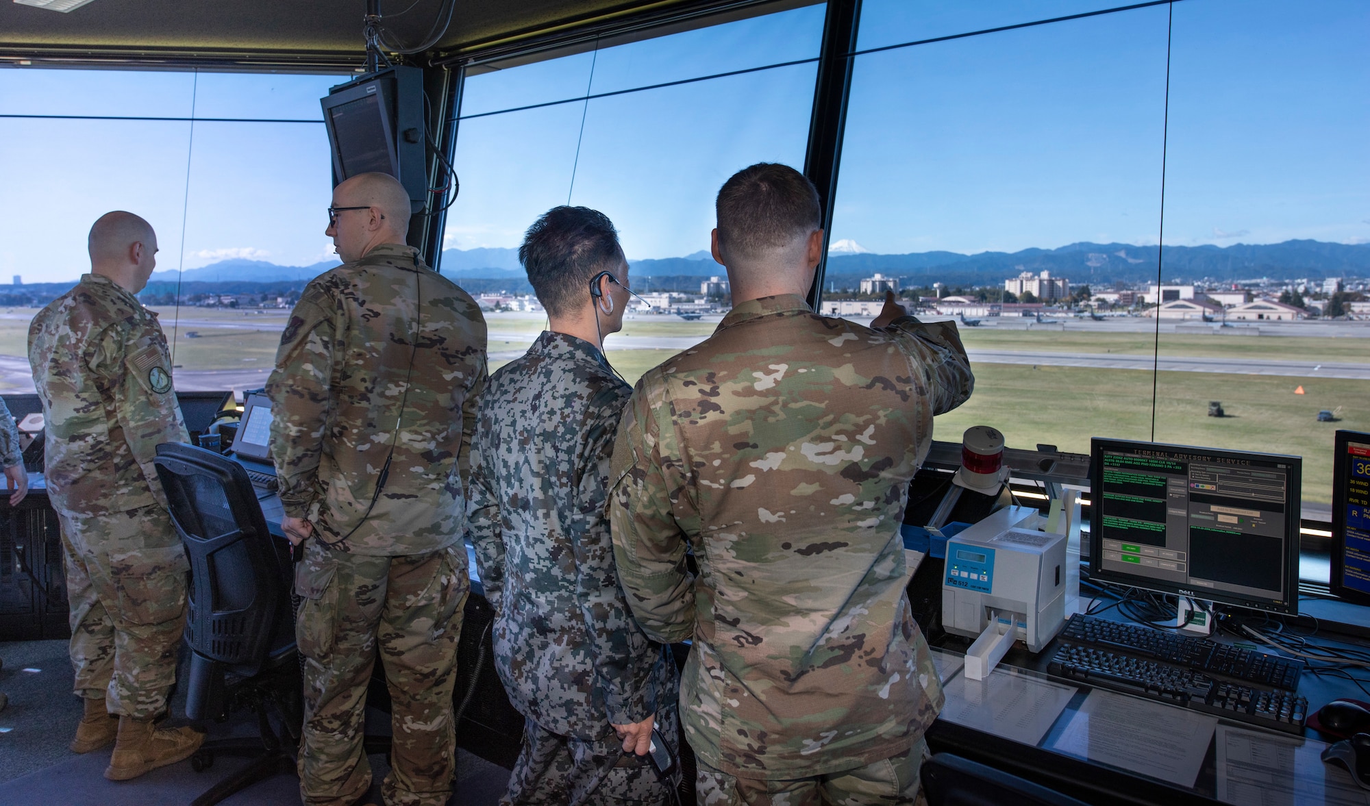 Senior Airman Kenyan Francis, 374th Operations Support Squadron air traffic controller, monitors flightline activity with Koku-Jieitai Tech. Sgt. Shinichi Ishimoto, Air Traffic Control Group air traffic controller assigned with Komatsu Air Base, Japan, from the air traffic control tower, Oct. 23, 2019, at Yokota Air Base.