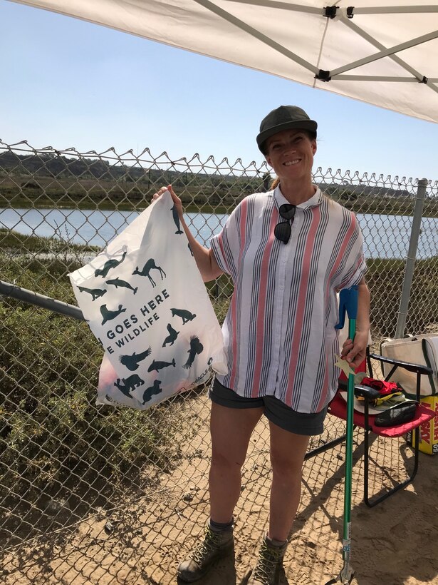 Tiffany Armenta holds up a bag of trash she collected during Coastal Cleanup Day Sept. 21 at the Santa Ana River Marsh in Newport Beach, California.